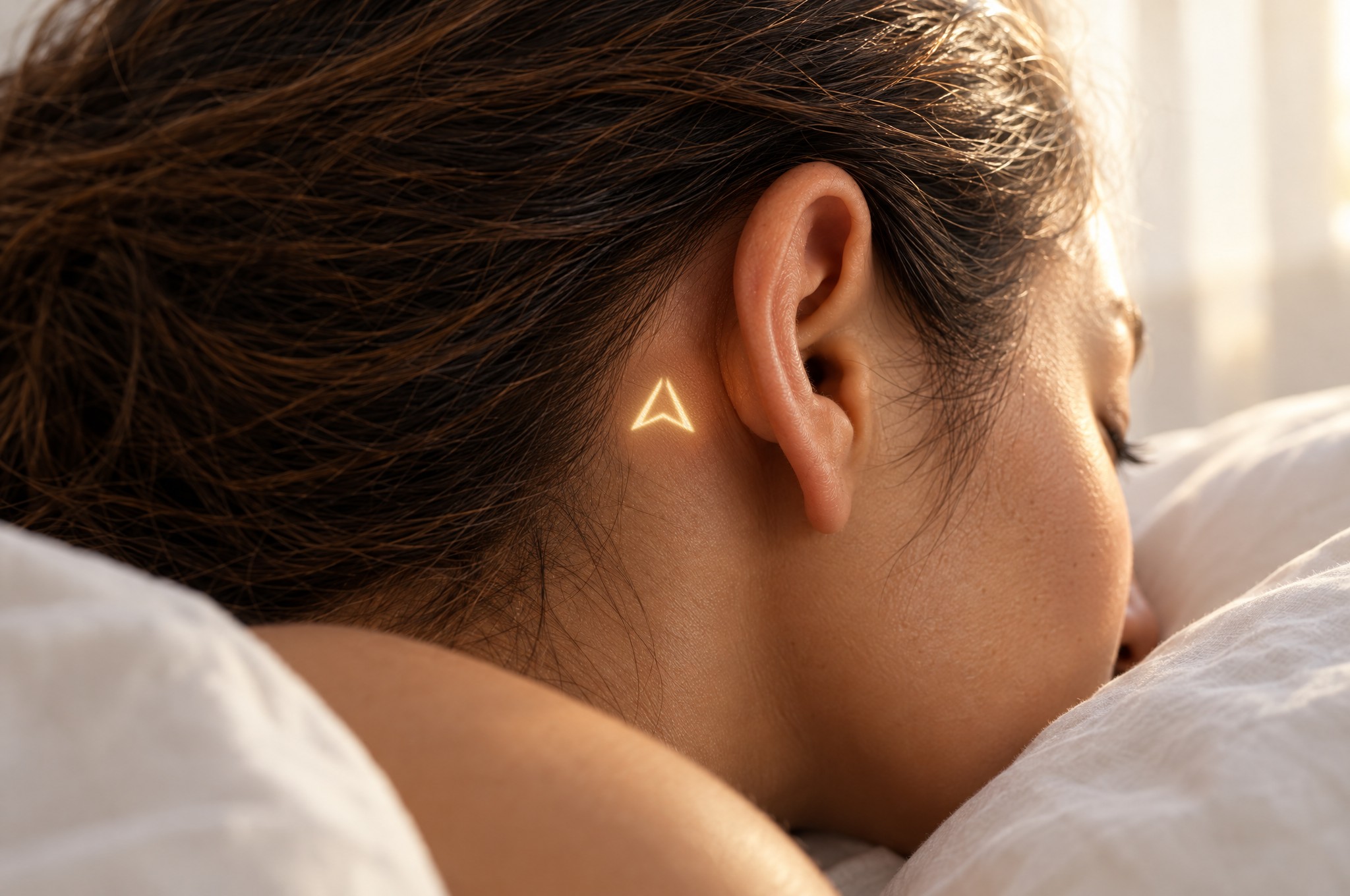 A woman asleep with the glowing Mark behind her ear
